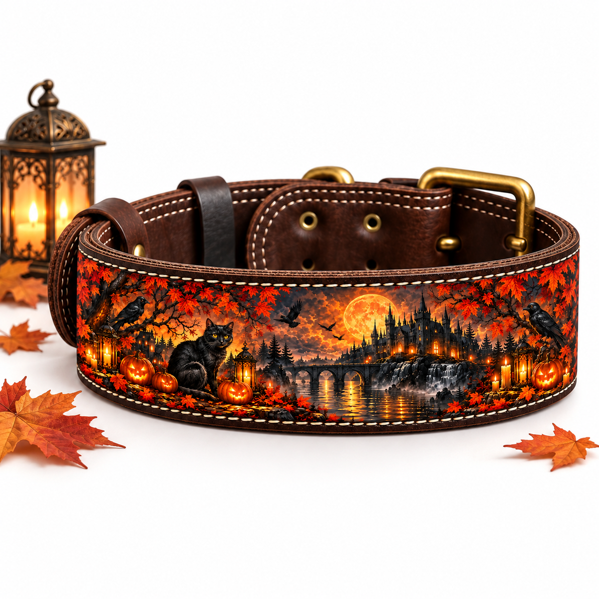 A brown leather dog collar with a detailed autumn landscape print featuring a black cat, pumpkins, crows, a bridge, and falling leaves, displayed on a white background with a decorative lantern and scattered leaves.