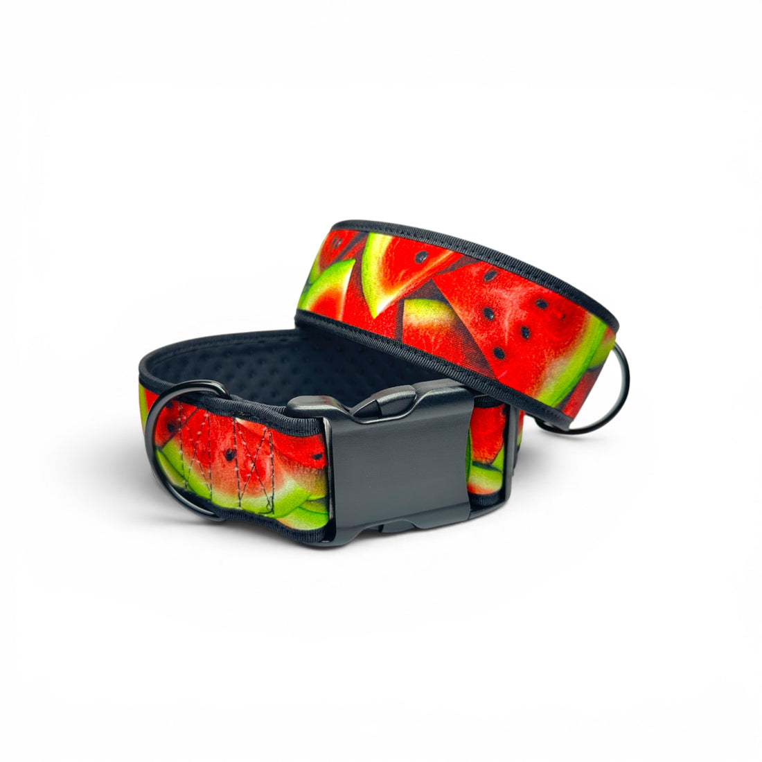 A dog collar with a vibrant watermelon slice print in red, green, and yellow, featuring a dark gray adjustable plastic buckle.
